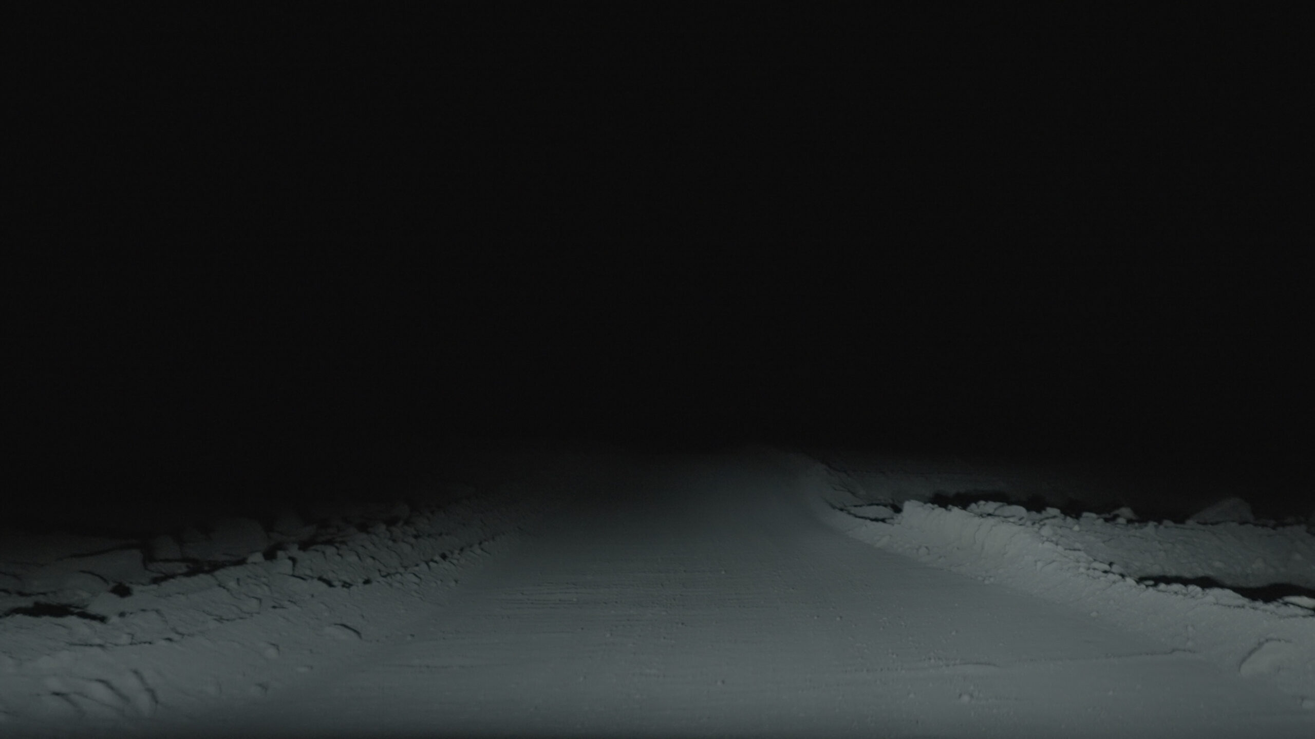 Snow covered road in the dark.